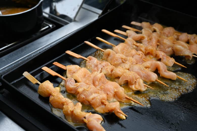 Gegrillte Saté Spieße mit hausgemachter Erdnusssauce - erdnuss sate spiesse 08 - 2 Sate Spieße auf der Plancha in der Zubereitung