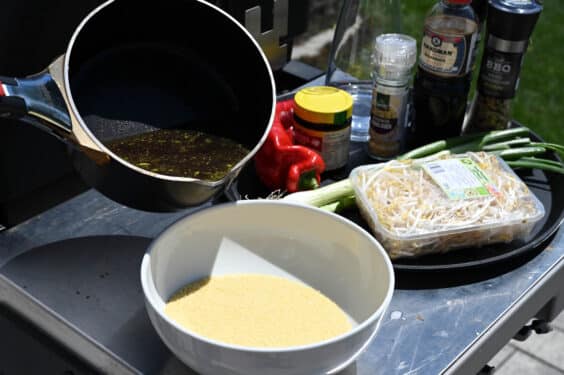 Den Couscous mit der Gemüsesuppe übergießen und quellen lassen